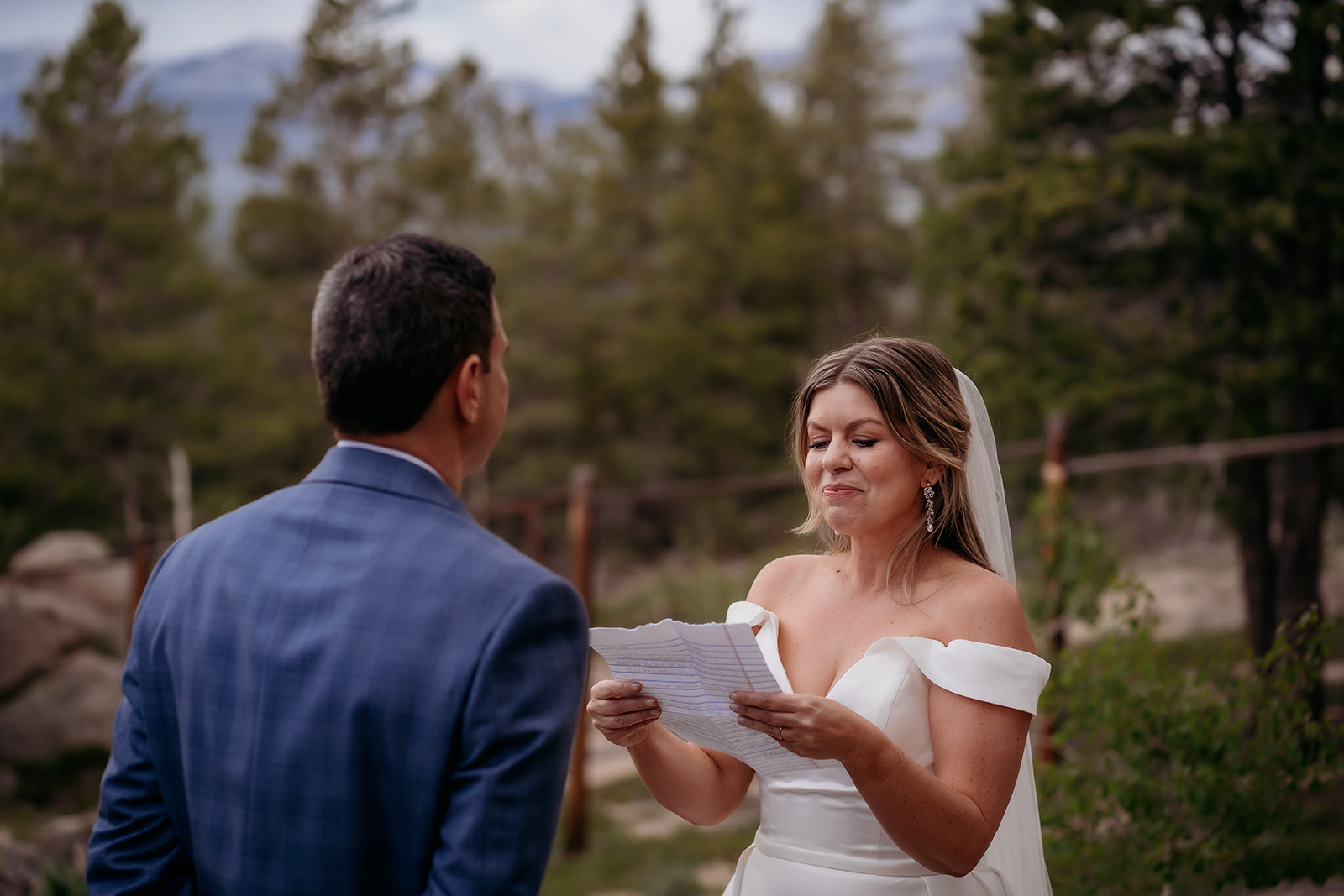 Bride reading heartfelt vows to her groom outdoors at their Colorado adventure elopement.