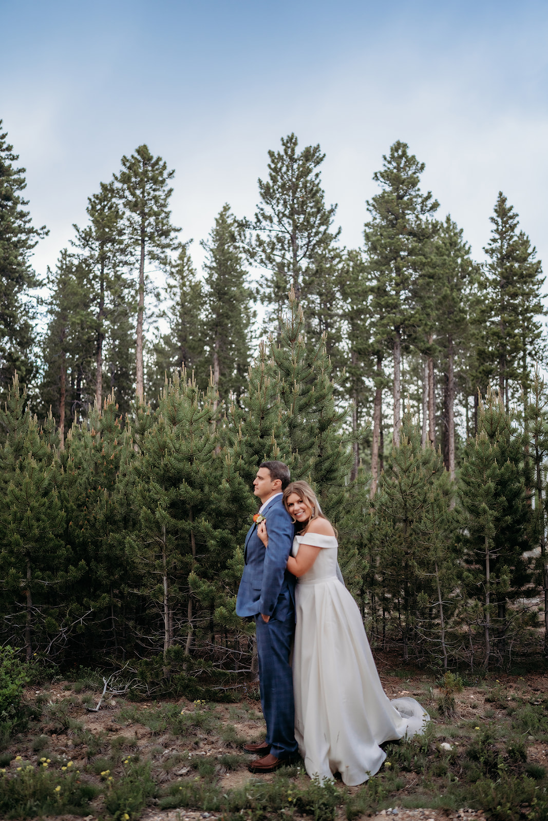 Bride and groom share a first look surrounded by tall pines during their Colorado adventure elopement.