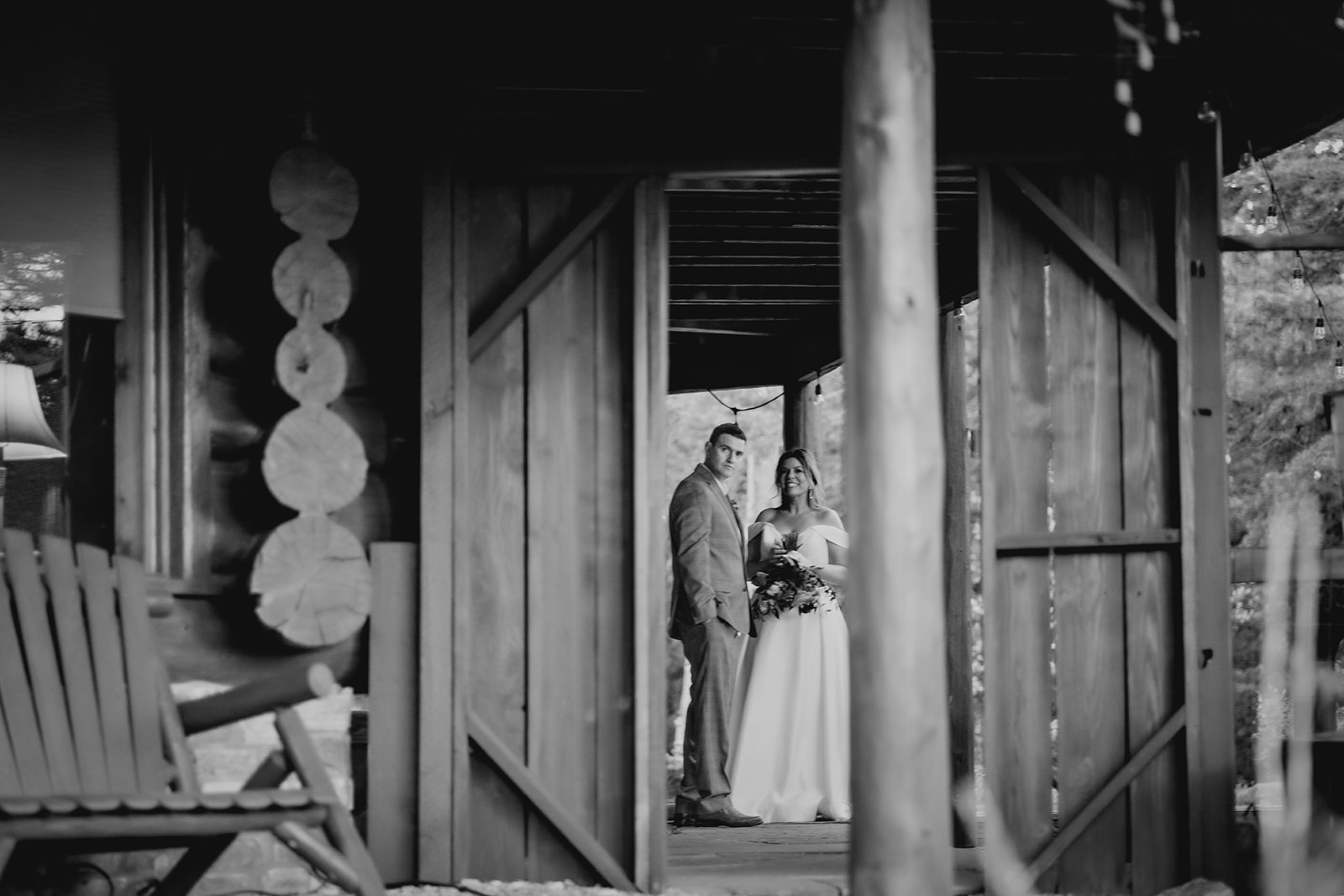 Black and white photo of bride and groom standing inside a rustic mountain cabin during their Colorado adventure elopement.