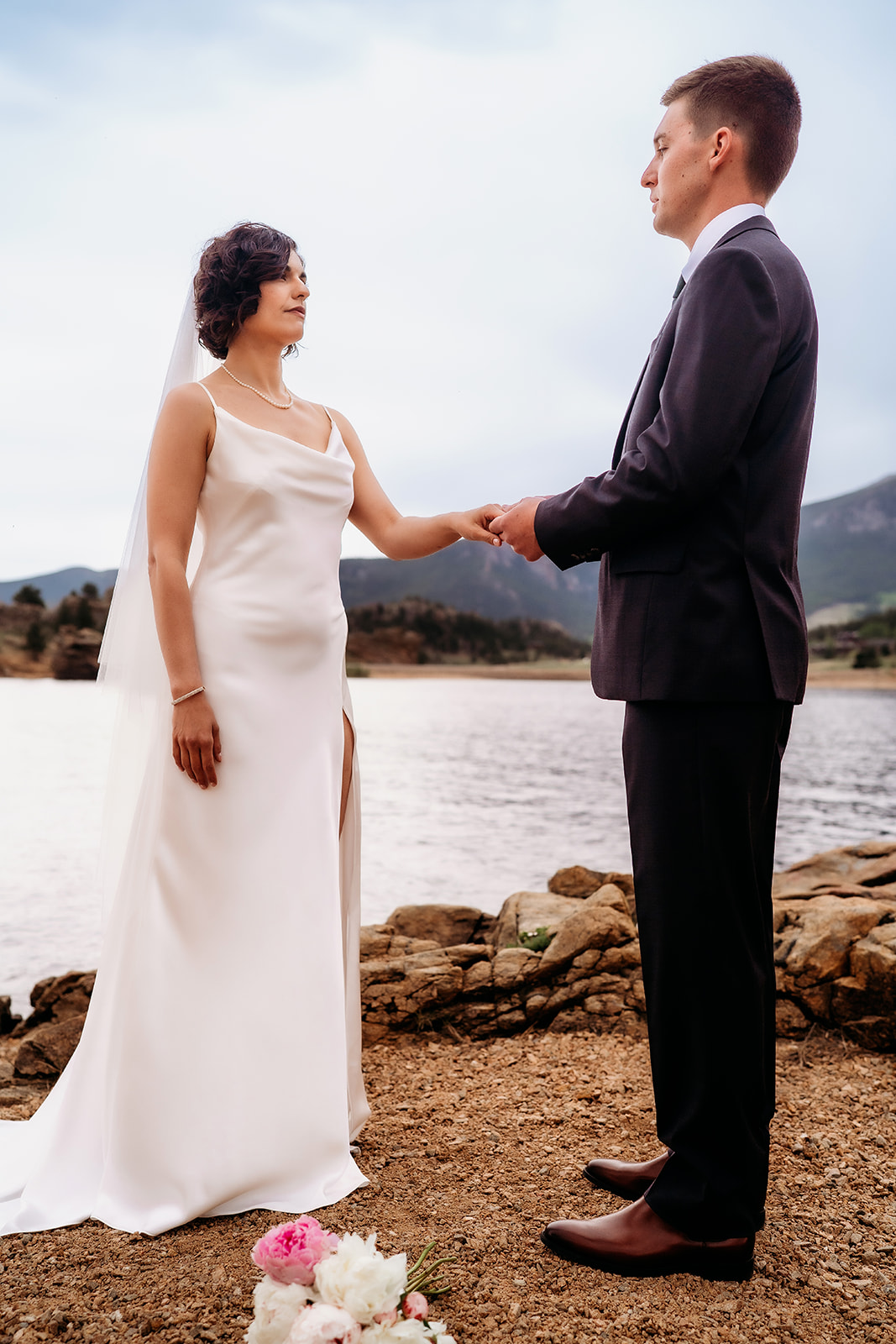 Bride stands confidently across from her groom during their personal lakefront vows in one of the most peaceful Colorado elopement locations.