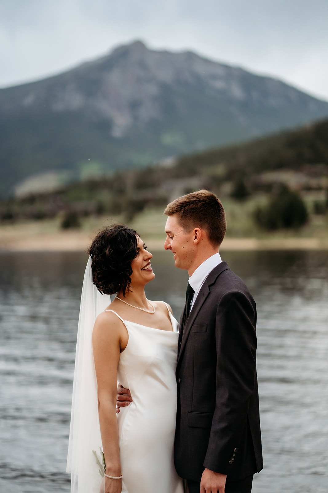 Bride reads vows to her groom during a heartfelt ceremony at one of the serene Colorado elopement locations by the water.