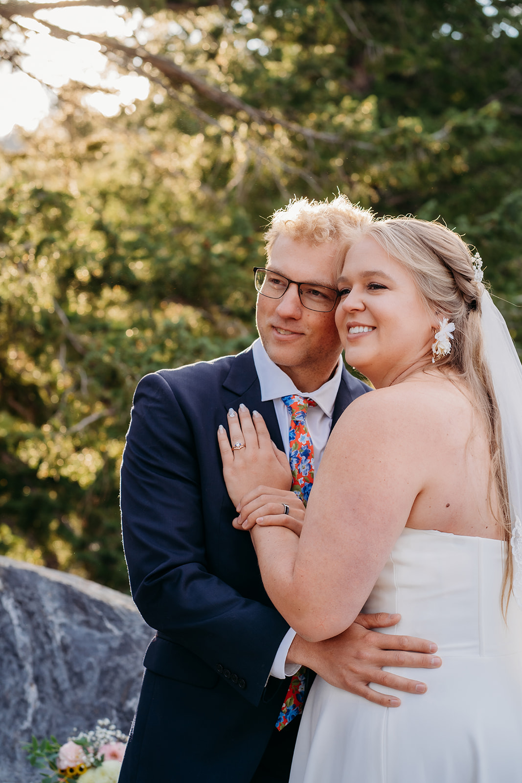 Close-up of smiling couple holding each other during their outdoor mountain wedding.