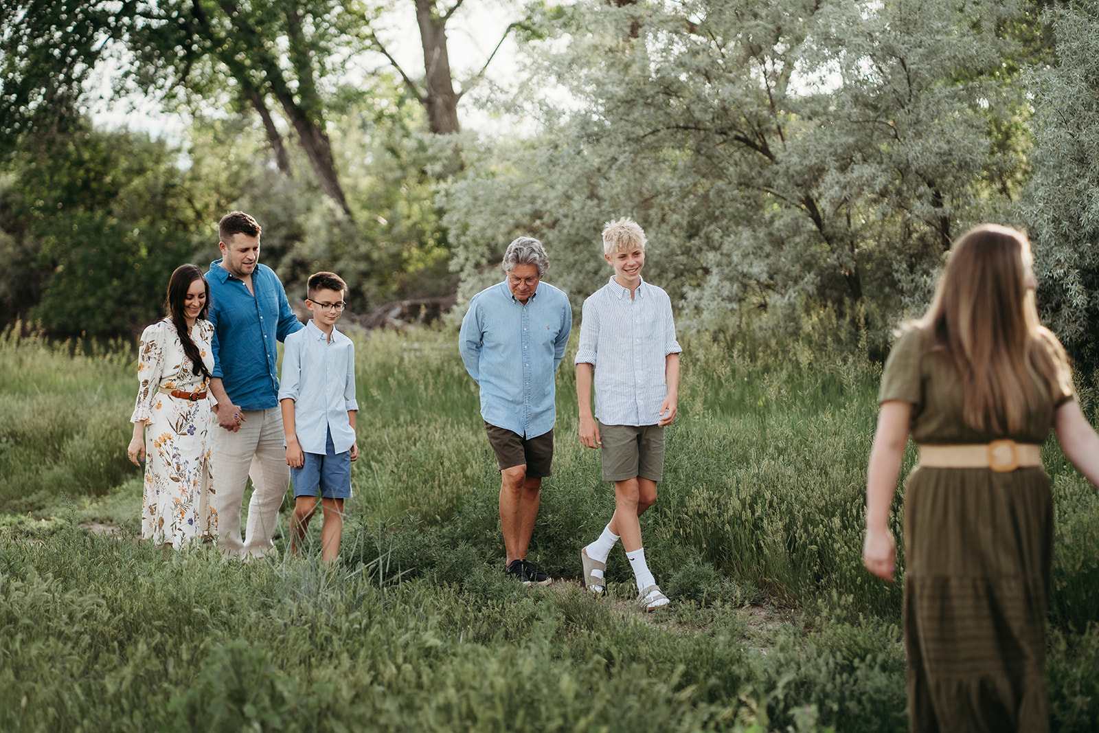 Family walking together along a path, wearing casual coordinated outfits for outdoor family photos.