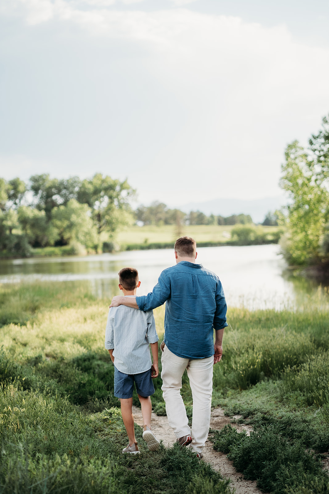 Father and son walking towards creek during outdoor family photos in Colorado