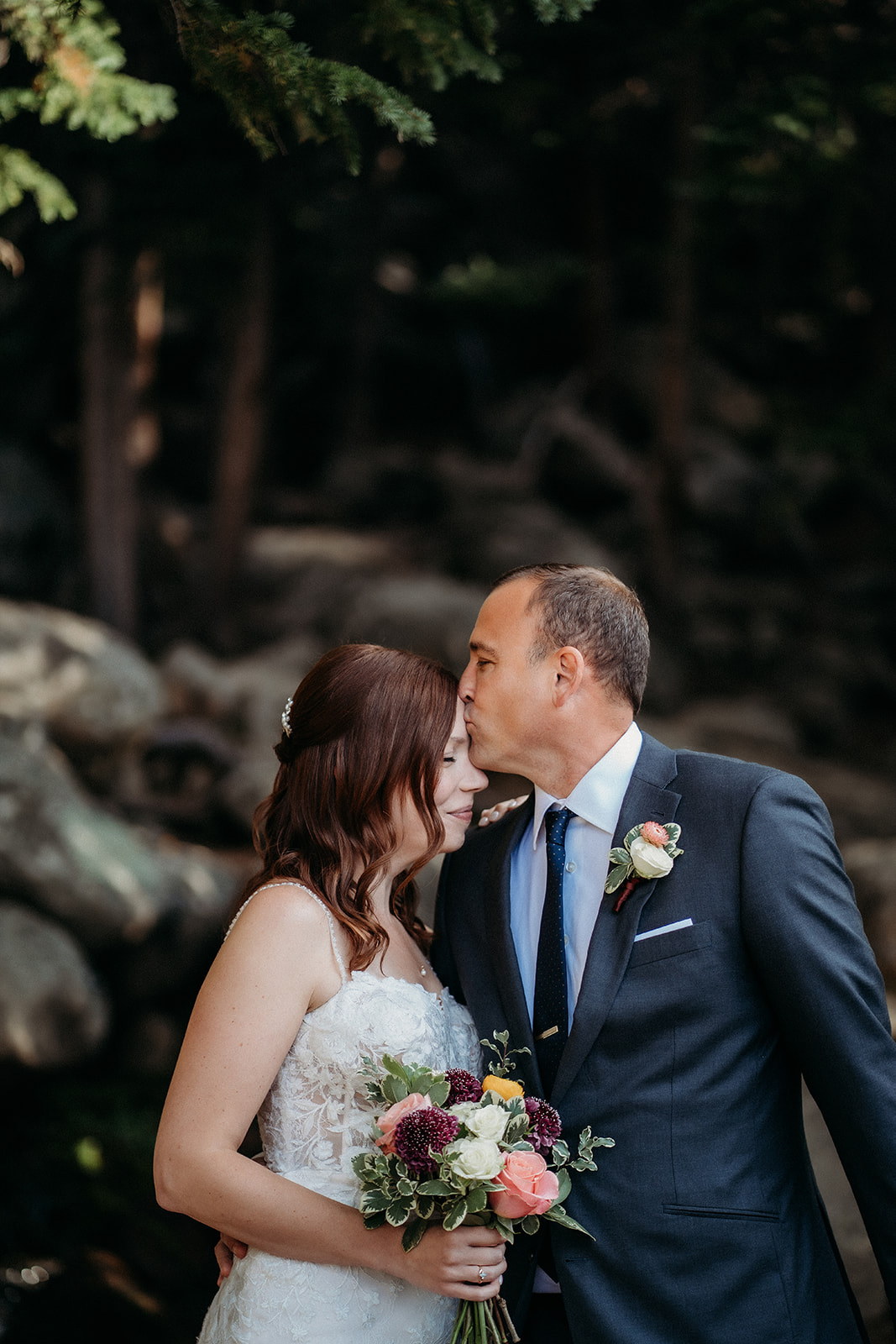 A soft kiss on the forehead, her bouquet cradled between them—this elopement in Colorado was full of tender moments.
