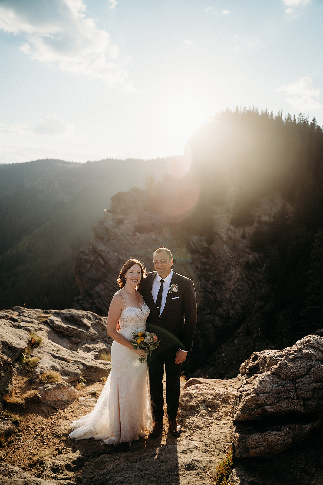 With golden light pouring in, the couple poses on the edge of a cliff, glowing after their Colorado vows.