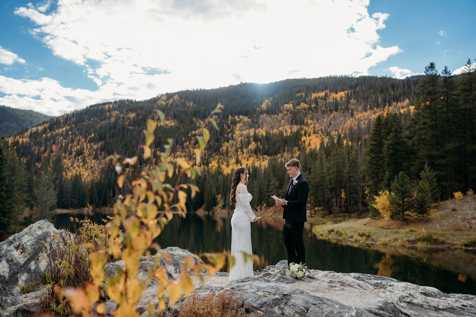 Holding hands and facing the golden hillside, this couple reads personal vows in a heartfelt elope to Colorado ceremony.
