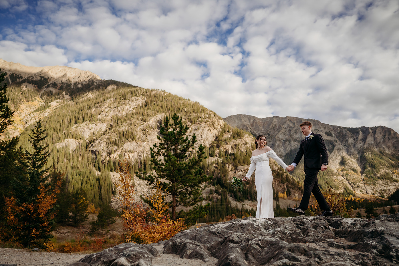 Walking hand in hand across a mountain ridge, the couple beams—proof that to elope to Colorado is to choose adventure.