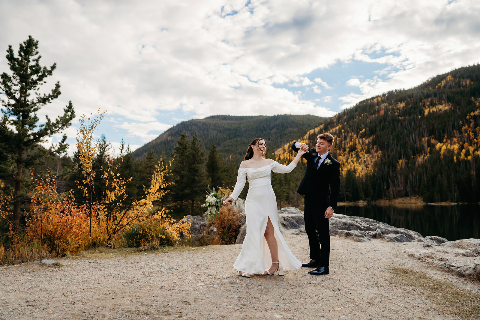 The groom twirls the bride beneath dramatic fall foliage and a glowing sky—one of many reasons couples elope to Colorado.