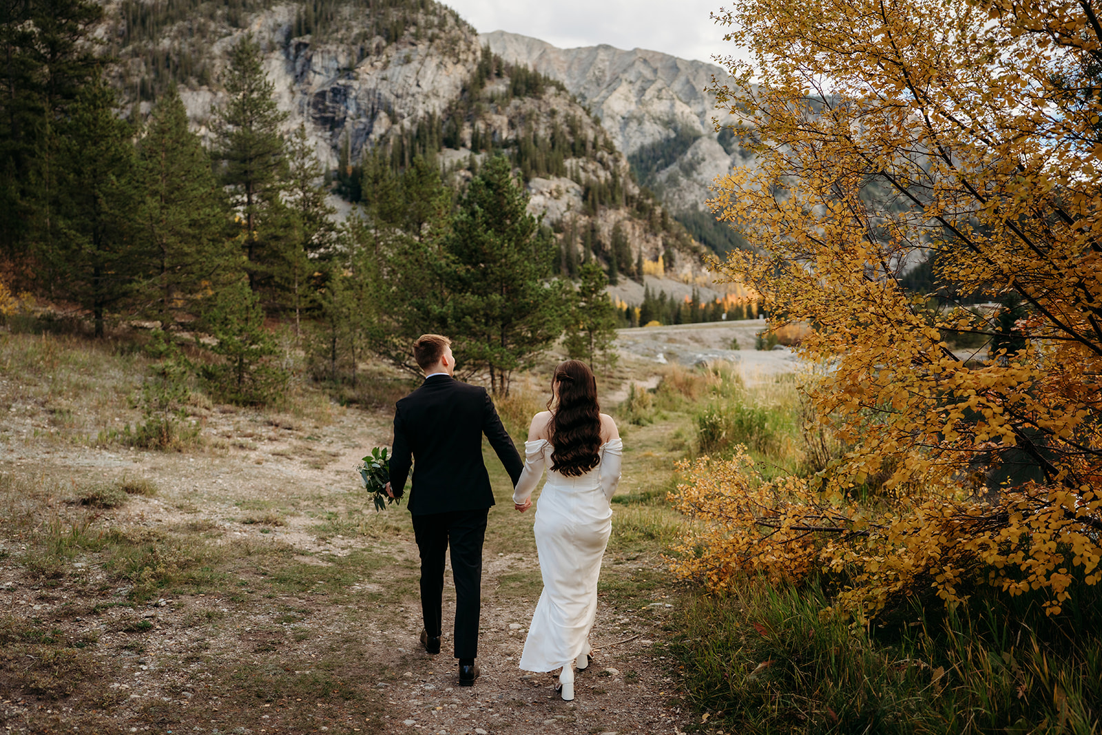 Couple walking through the forest after elopement in Colorado