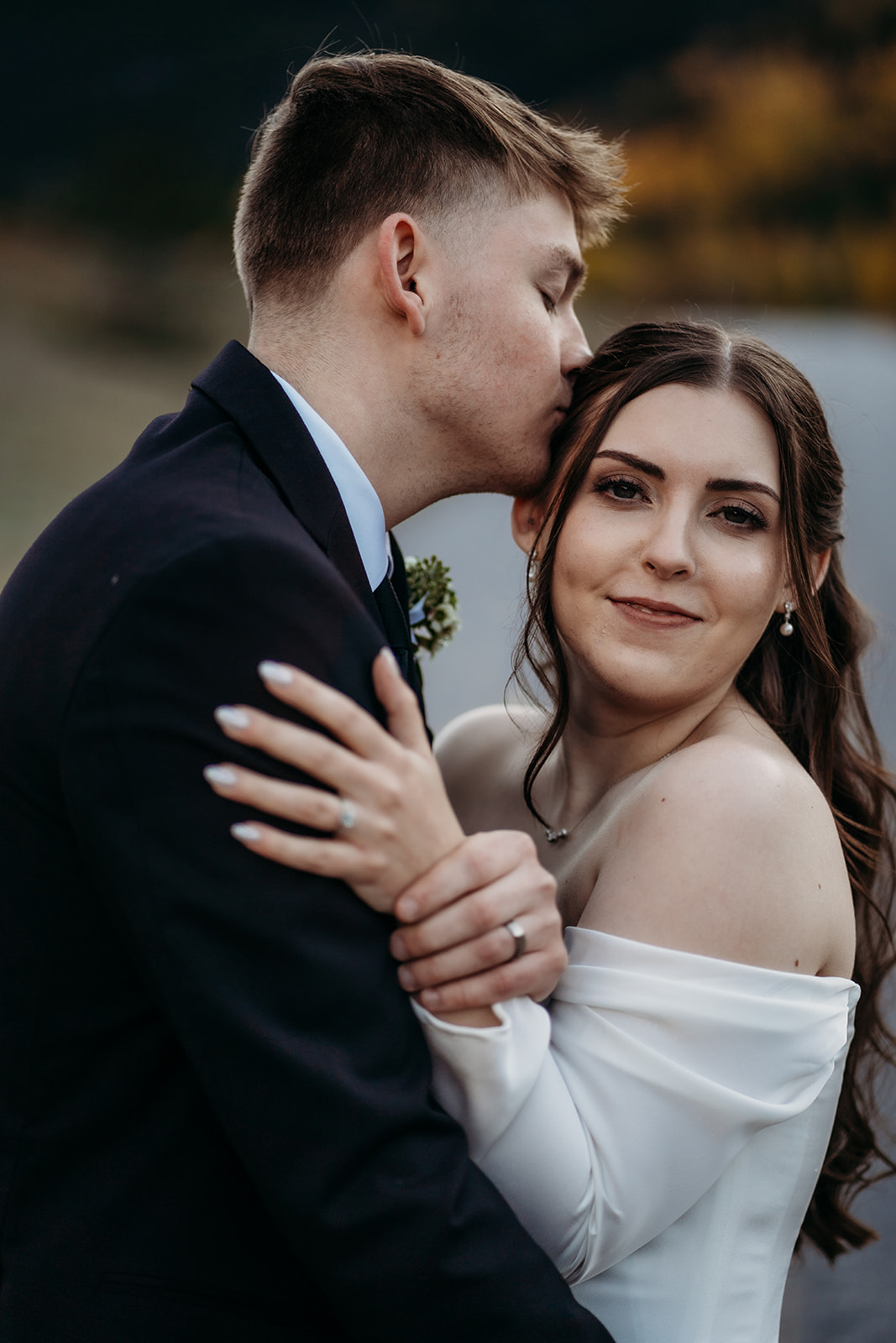 A soft kiss on the cheek from the bride captures the joyful intimacy of their mountain elopement.
