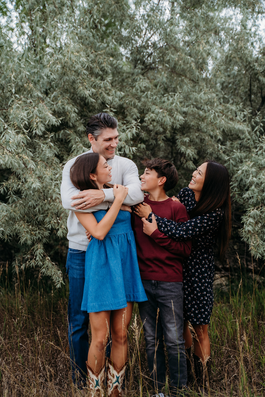 Candid laughter and hugs during a playful moment—this is what great family outdoor pictures are made of.