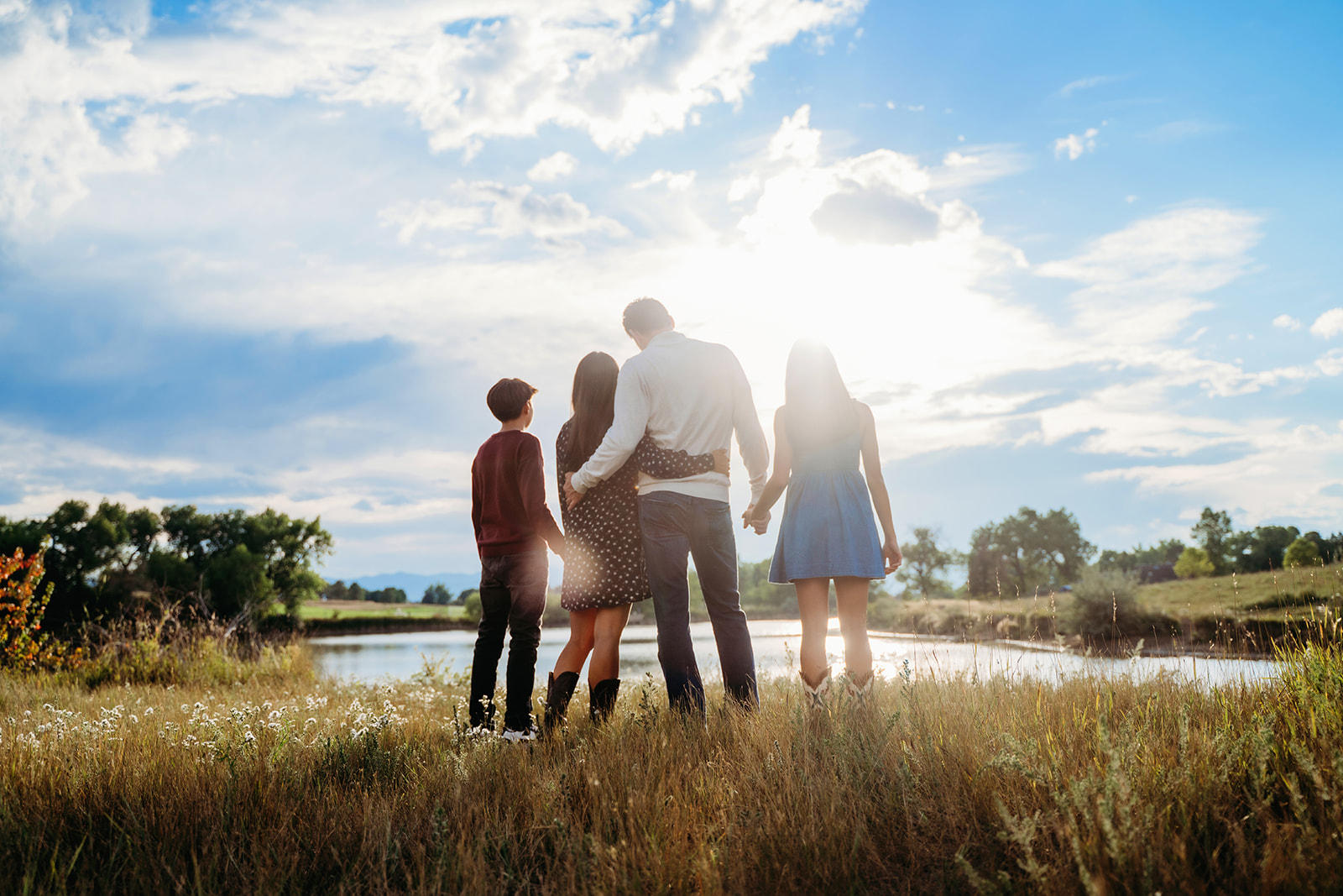 With their backs to the camera and eyes on the glowing sky, the family takes in the stillness of nature together.
