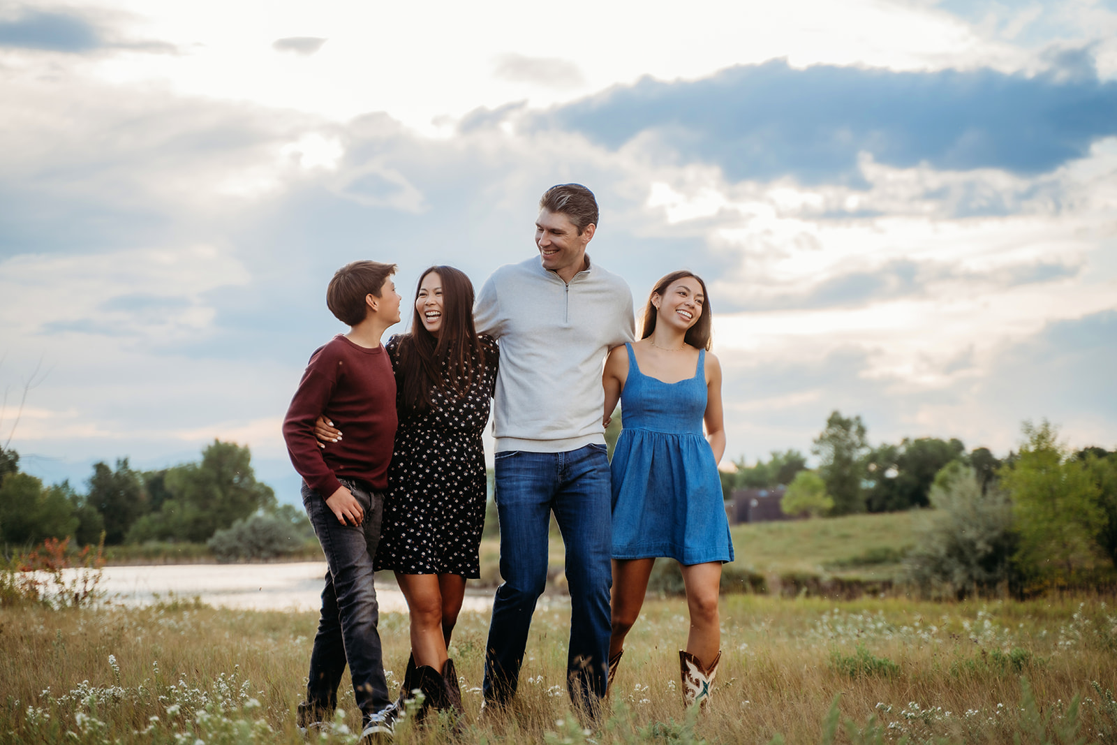 Walking arm in arm through the tall grass, this family looks completely at ease in their family outdoor pictures.
