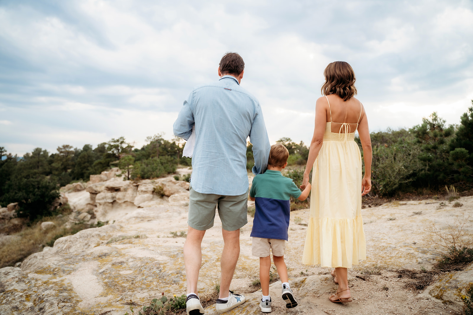Family walking away on a scenic trail, hand-in-hand, capturing a natural and candid moment in the great outdoors.