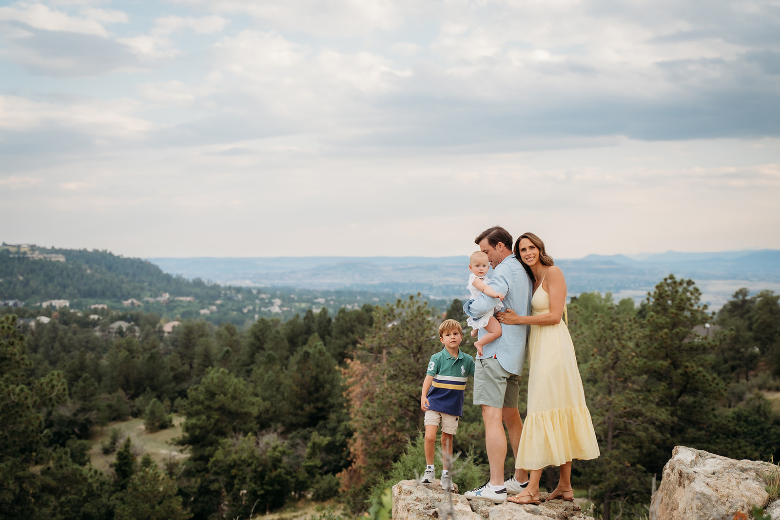 Family posing on a mountaintop with panoramic views—framing your location is one of the top family photo tips for outdoor sessions.