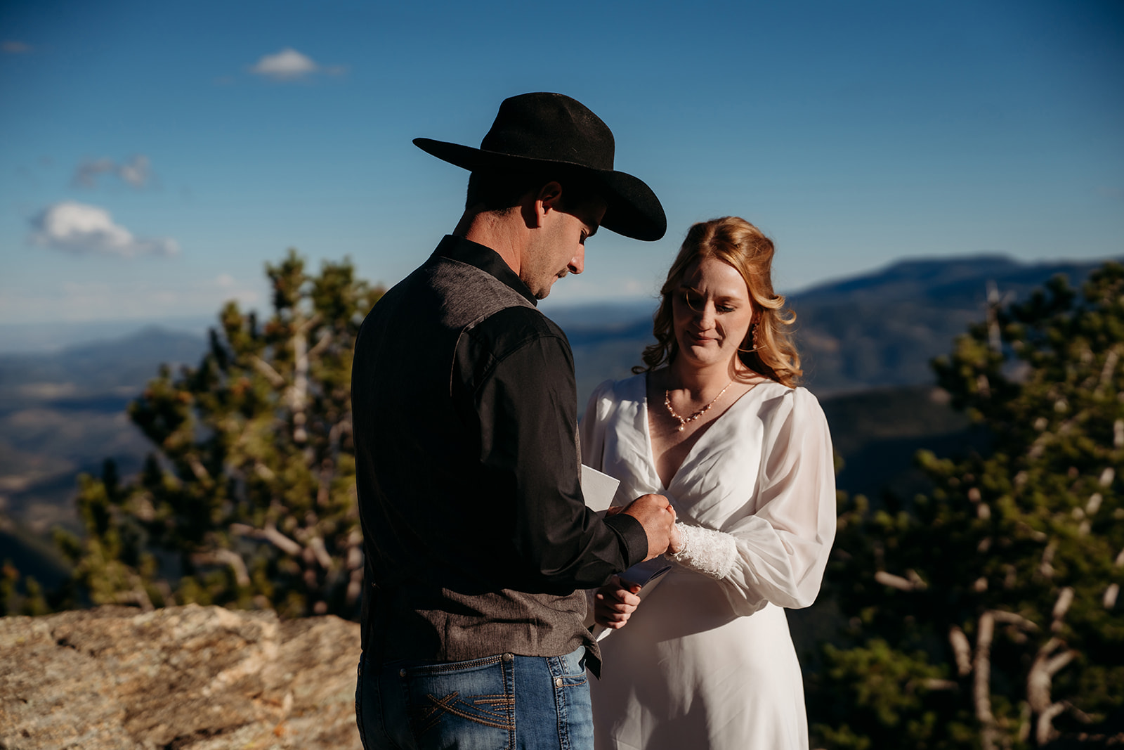 Groom reads heartfelt vows to his bride during their mountaintop ceremony, capturing the emotional power of knowing how to write vows that truly connect.
