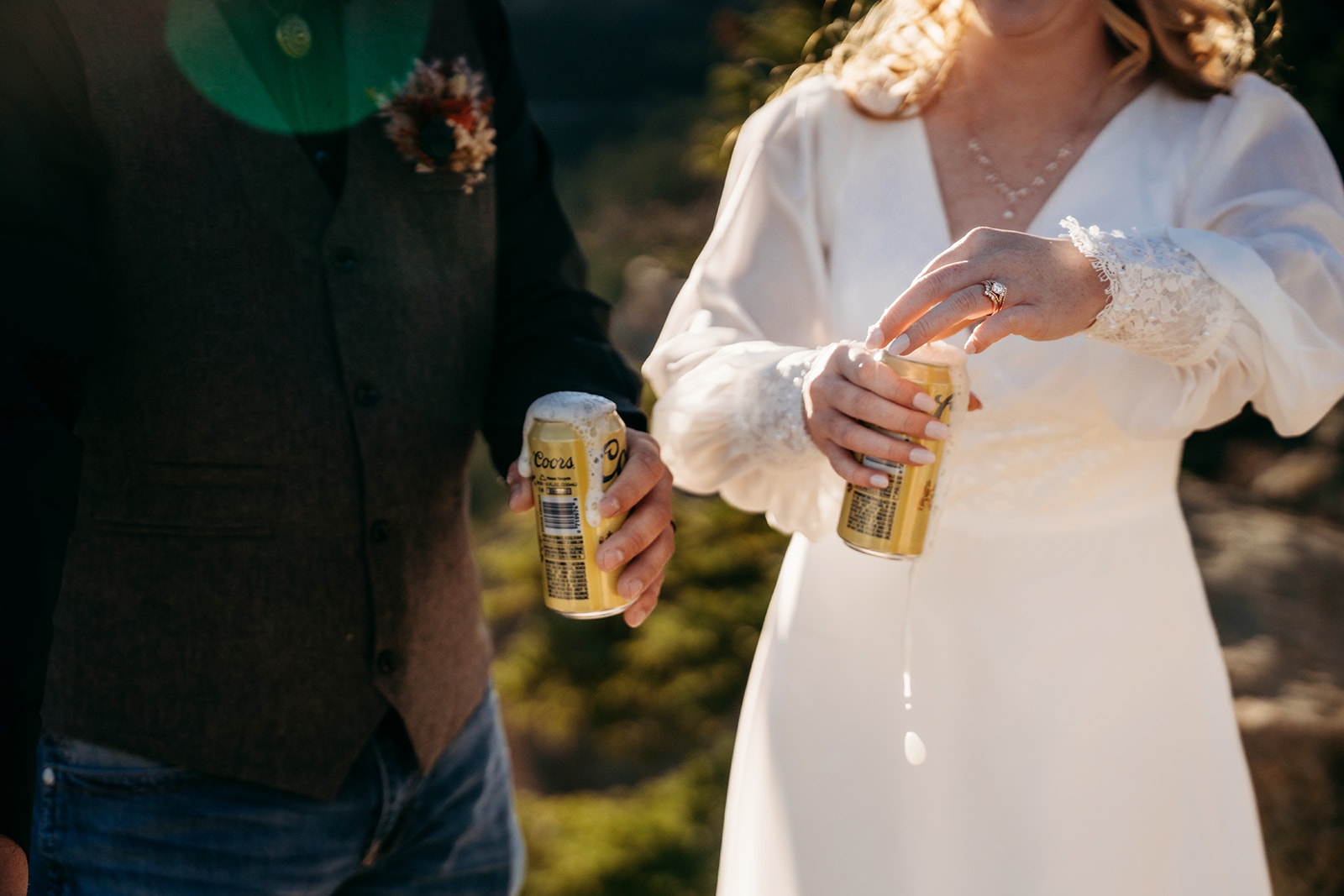 Bride opens a can of beer while laughing with her groom, a lighthearted moment after a heartfelt vow exchange.