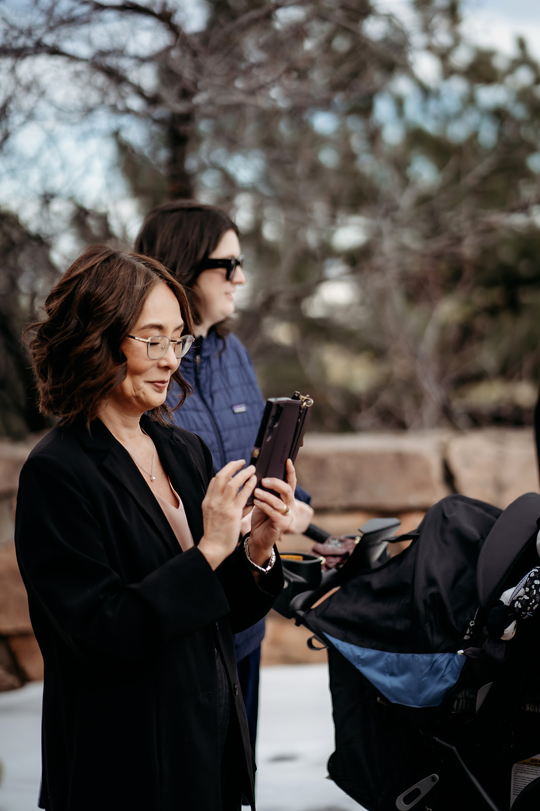 Guest capturing a sweet ceremony moment on her phone with snow in the background.