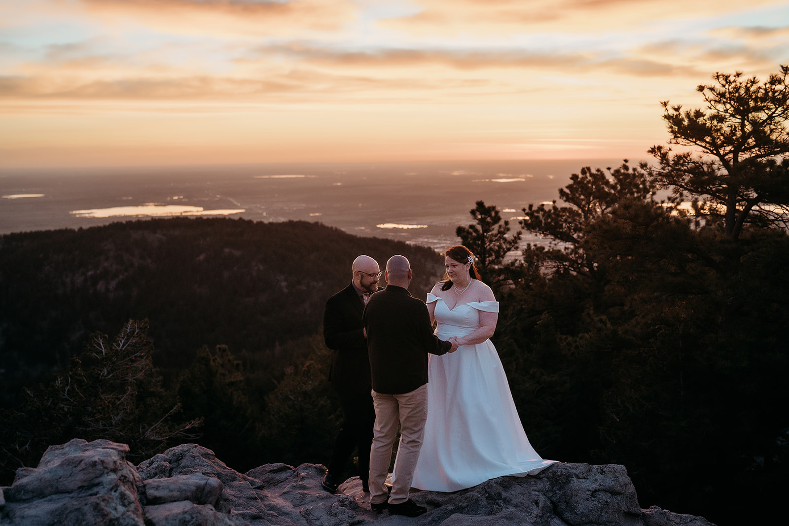 Mountaintop ceremony as the couple exchanges vows at sunset, with sweeping views captured by an elopement photographer Colorado couples trust.