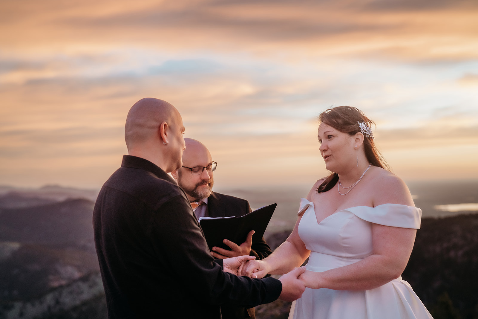 Close-up of vows being exchanged with mountains behind them, captured in real time by an experienced elopement photographer Colorado.