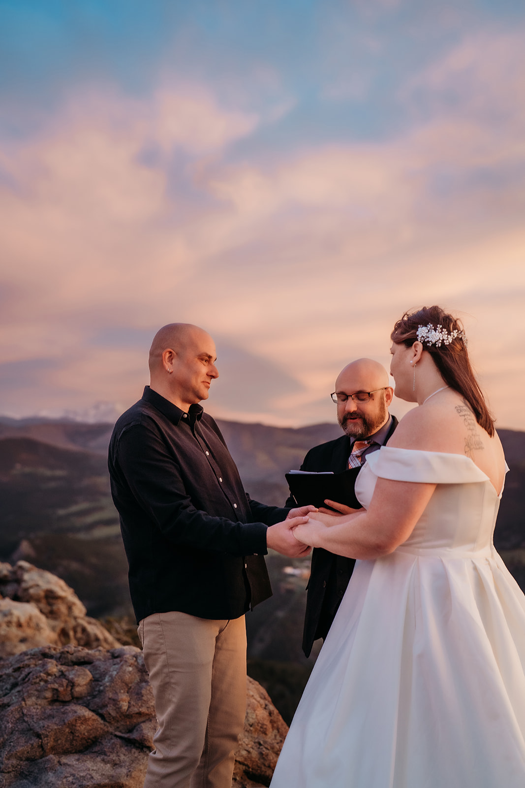 A tender vow exchange with sweeping mountain views behind them, beautifully documented by an experienced elopement photographer in Colorado.