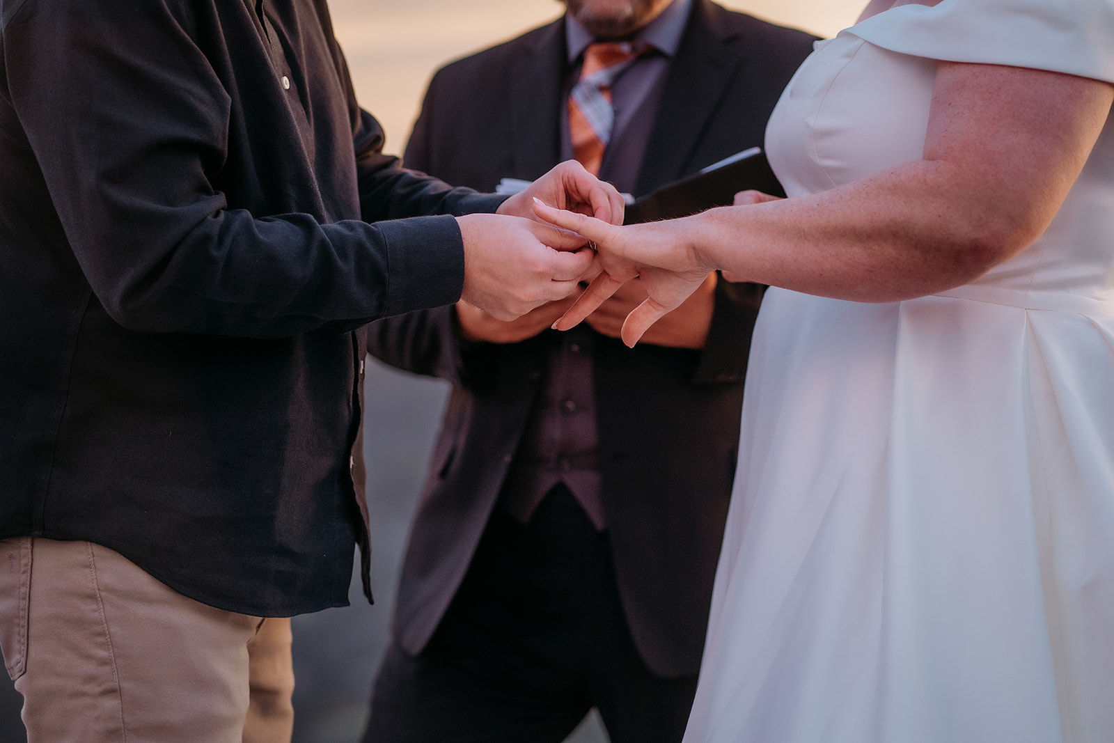 A close-up of the couple exchanging rings mid-ceremony, their hands centered as part of their intimate Colorado elopement story.