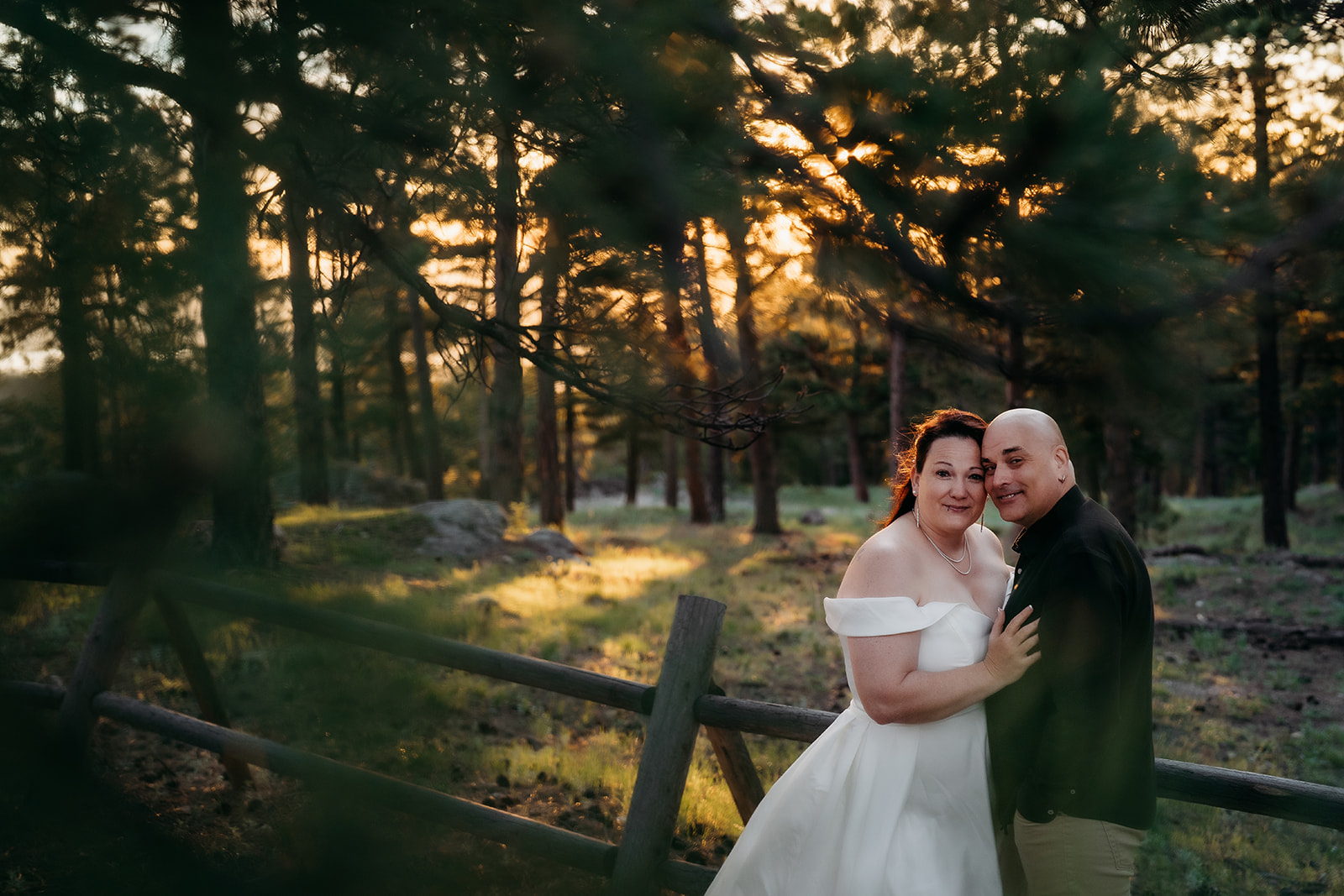 Nestled in the forest, the couple leans in close with warm smiles—just married and soaking in the moment.