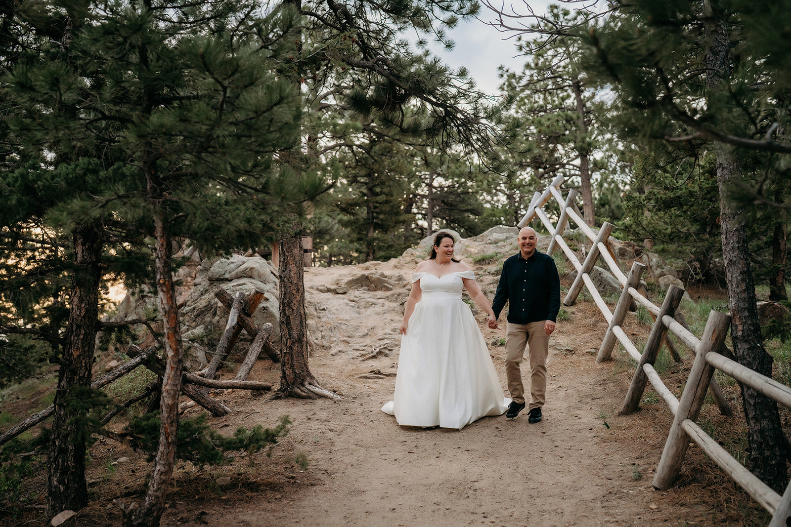 Hand in hand, the couple strolls down a tree-lined trail, glowing with post-ceremony joy—documented by an elopement photographer Colorado.