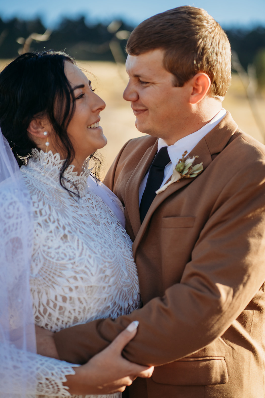 Tight portrait of the couple gazing at each other with soft smiles, captured in golden hour light after their Boulder elopement ceremony.