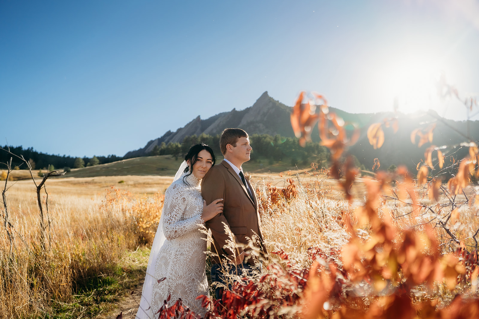 Bride resting her head on the groom’s shoulder, surrounded by golden fields and vibrant fall colors in a quiet Boulder elopement moment.