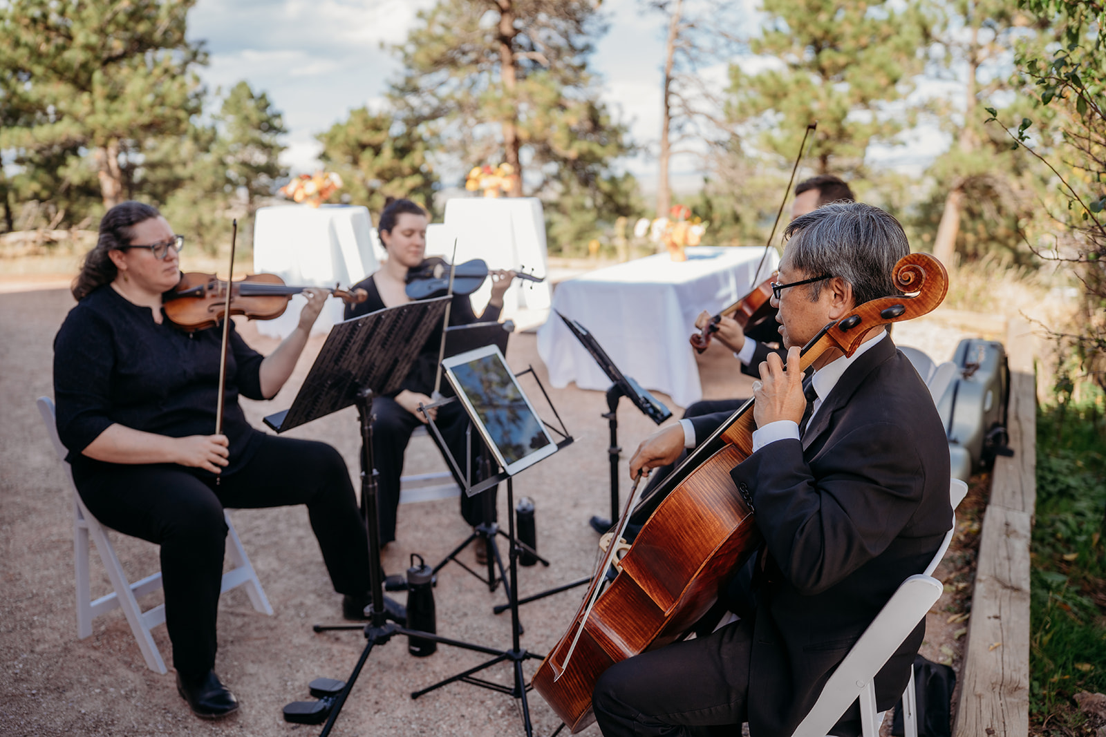 A small string ensemble performing live music outdoors during a ceremony, adding an elegant touch to a Colorado wedding celebration.