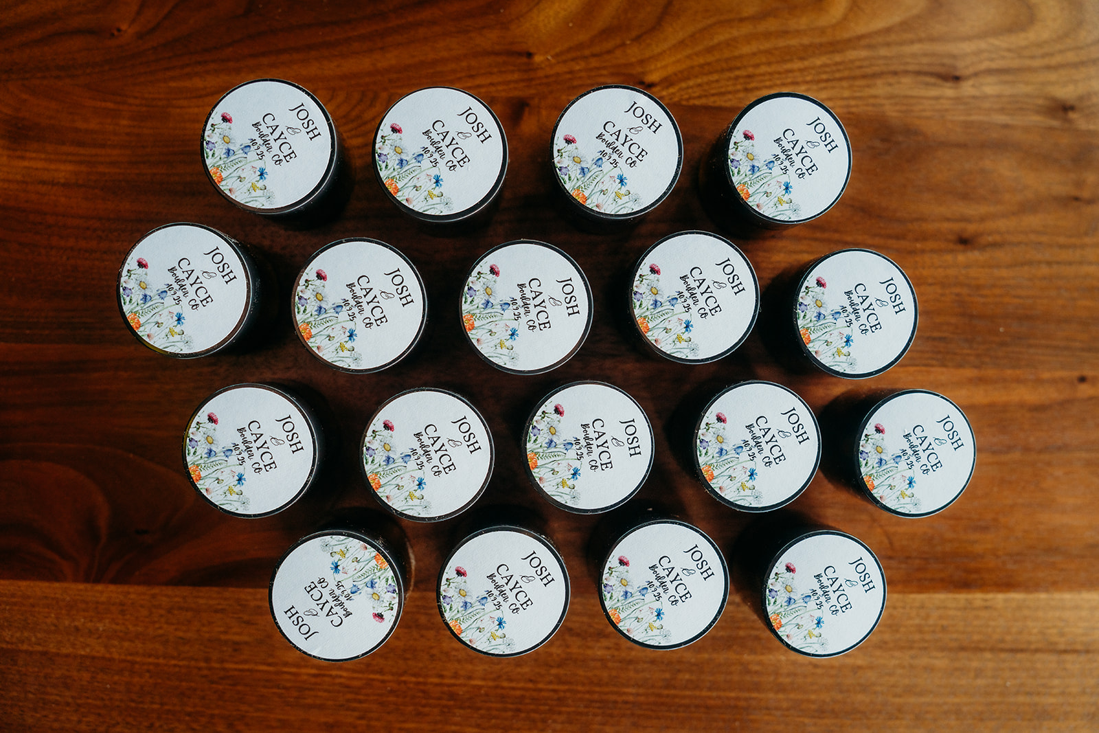 A collection of small wedding favors arranged neatly on a wooden table, each labeled for guests at a Colorado wedding.