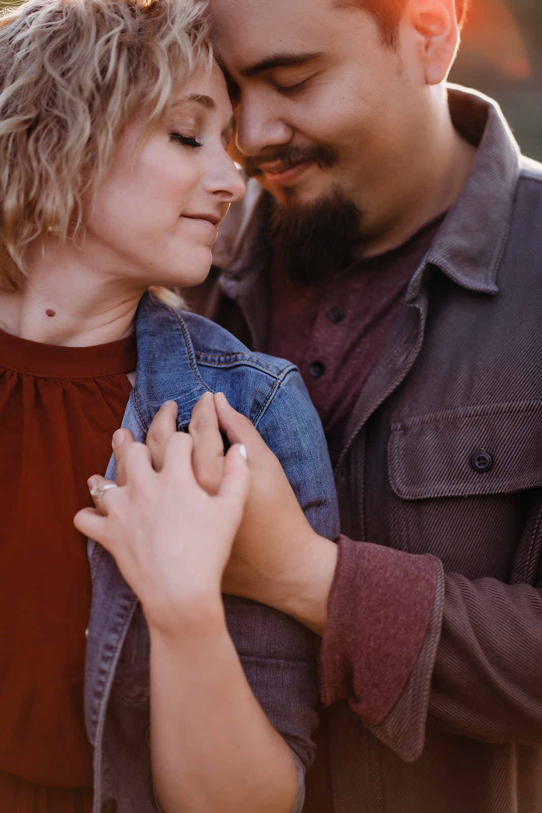 Close-up of a couple embracing tenderly, eyes closed and smiling, captured by a Denver engagement photographer.